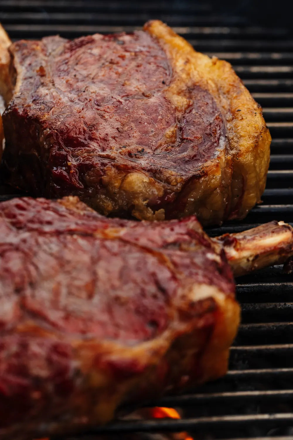 Tomahawk steaks searing over open flame