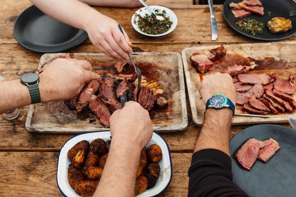 Guests sharing carved meats and sides at a long table