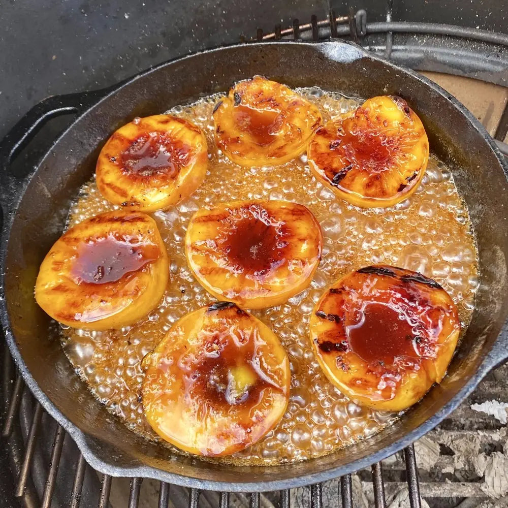 Peaches caramelising in a skillet of Madeira sauce